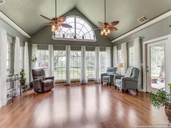 a living room with furniture a chandelier and a large window