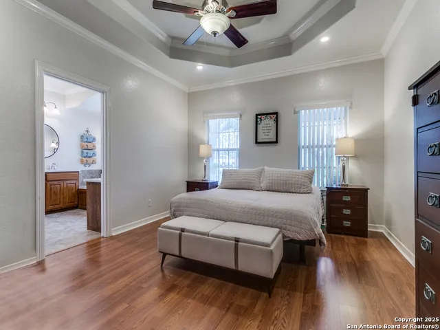 a spacious bedroom with a bed and wooden floor