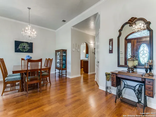 a view of a dining room with furniture a chandelier and wooden floor