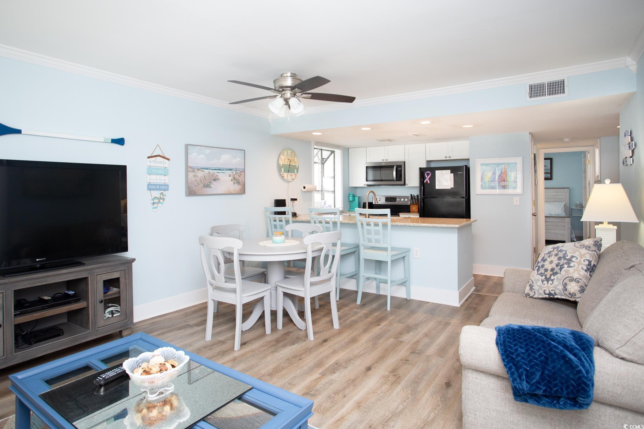 Living room featuring ceiling fan, light wood-type flooring, and crown molding