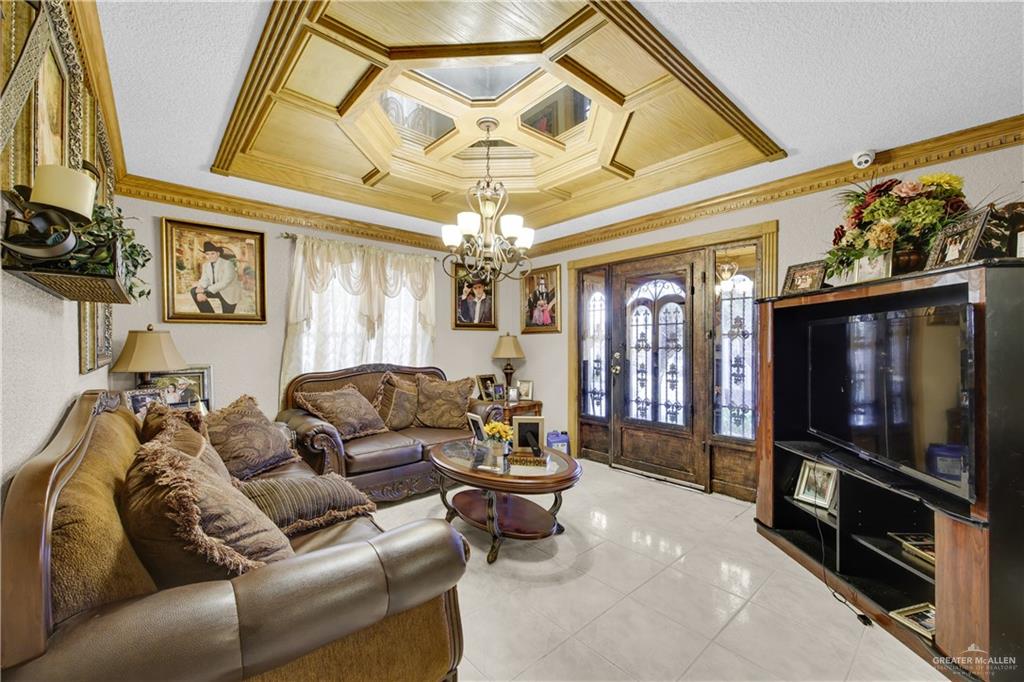 309 Domingo Navarez Street Rio Grande City, TX 78582 - Photo 5 of 14 Tiled living area with crown molding, plenty of natural light, coffered ceiling, suspended lighting, and a textured ceiling