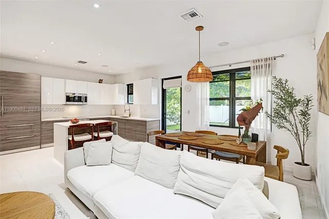 a living room with furniture a fireplace and a chandelier