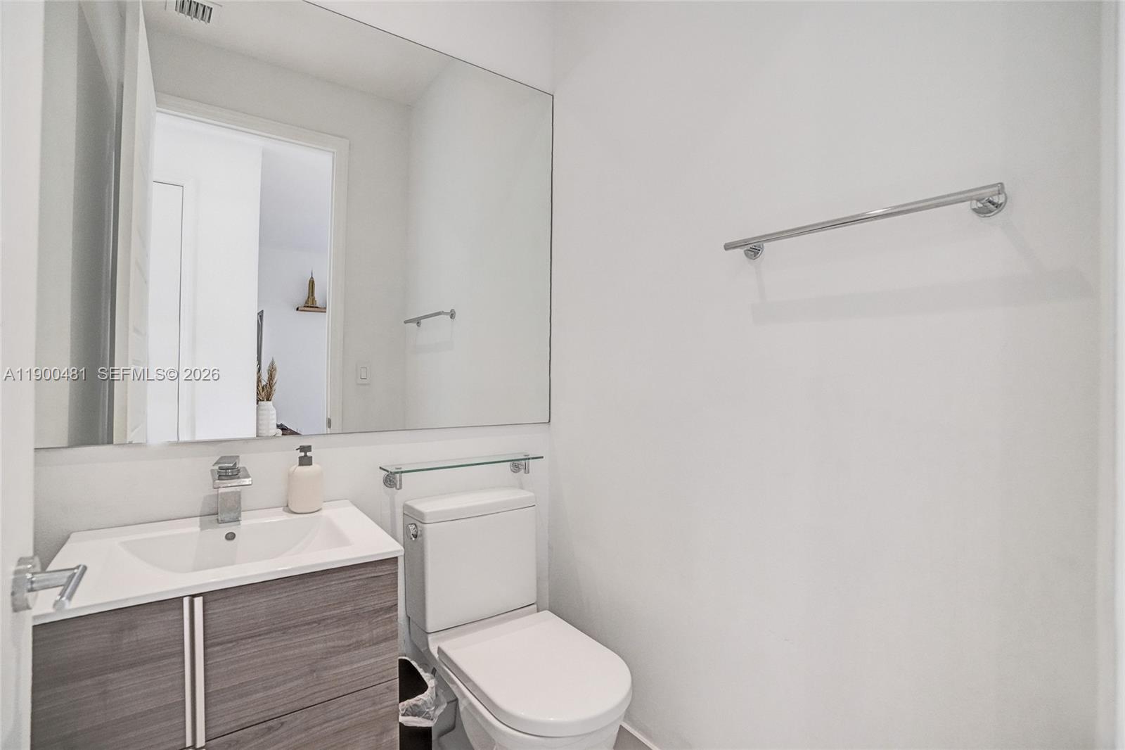 650 Northeast 193rd Terrace Miami, FL 33179 - Photo 10 of 32 a bathroom with a toilet a sink a mirror and vanity