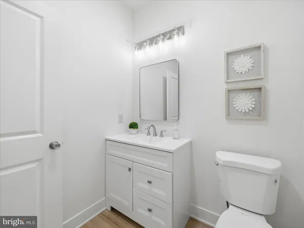 a bathroom with a toilet sink a mirror and vanity