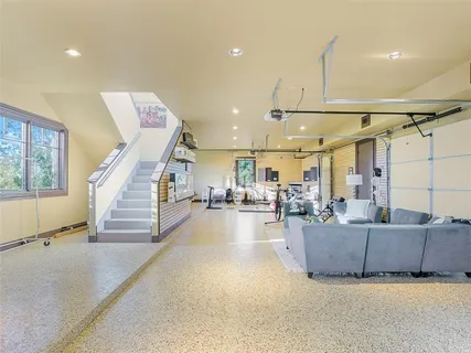 a living room with couches and kitchen view with wooden floor