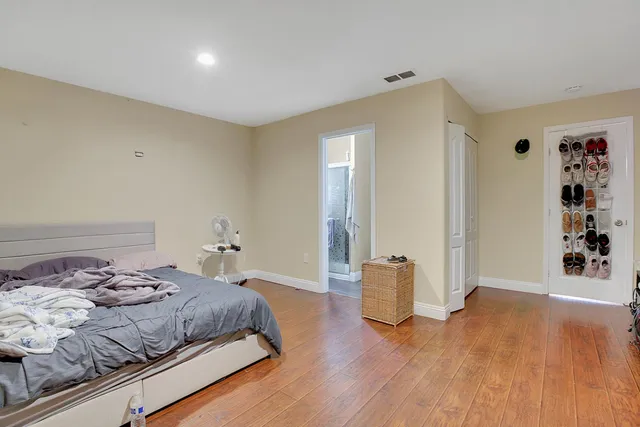 a bedroom with a bed and wooden floor