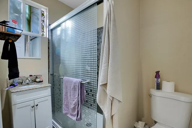 a bathroom with a granite countertop sink a vanity and a shower