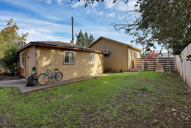 a view of a backyard with potted plants and a wooden fence