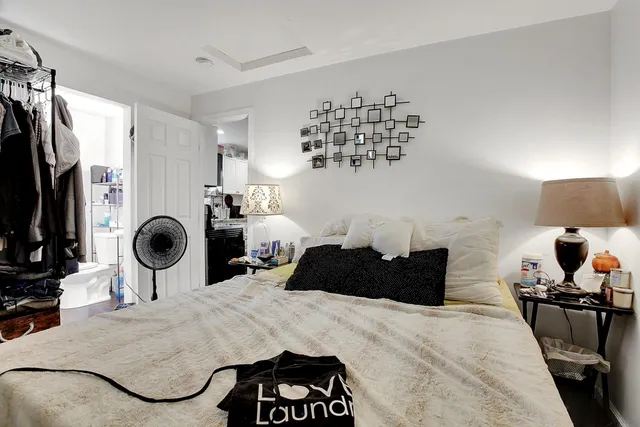 a bedroom with a bed a couch and a chandelier