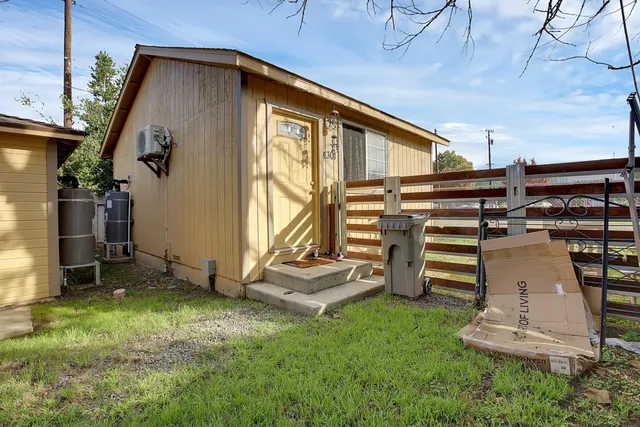 a backyard of a house with barbeque oven and wooden fence