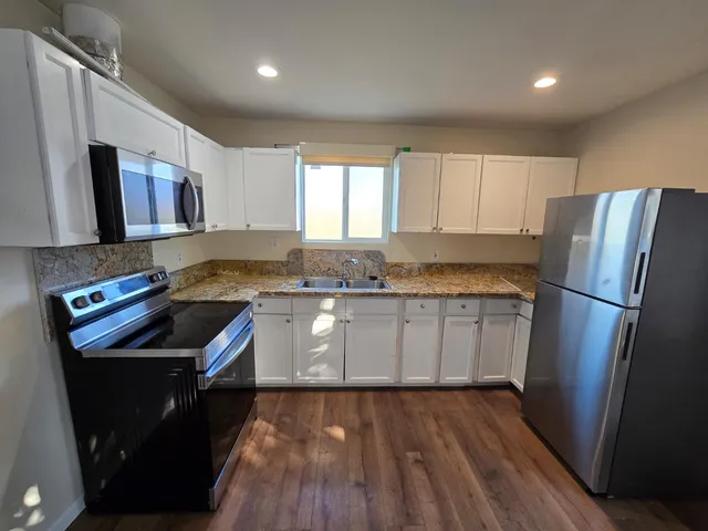 a kitchen with a sink a refrigerator a microwave oven and cabinets