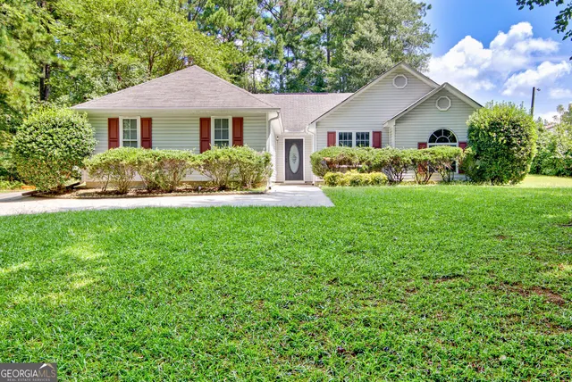 a front view of a house with a yard and trees