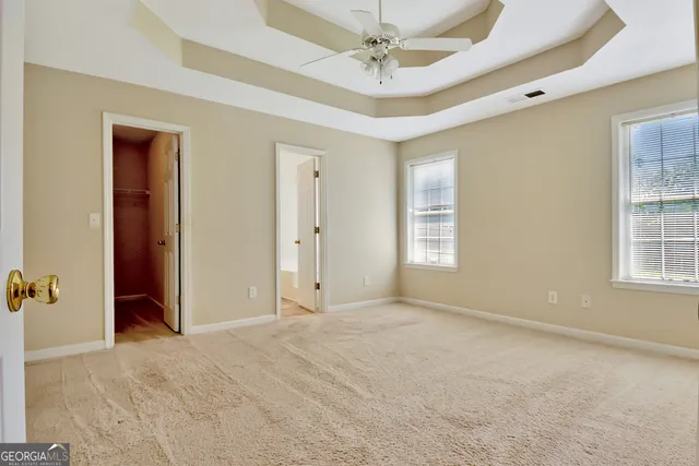 an empty room with fan and a bathroom