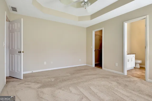 a bathroom with a granite countertop sink a toilet and a mirror