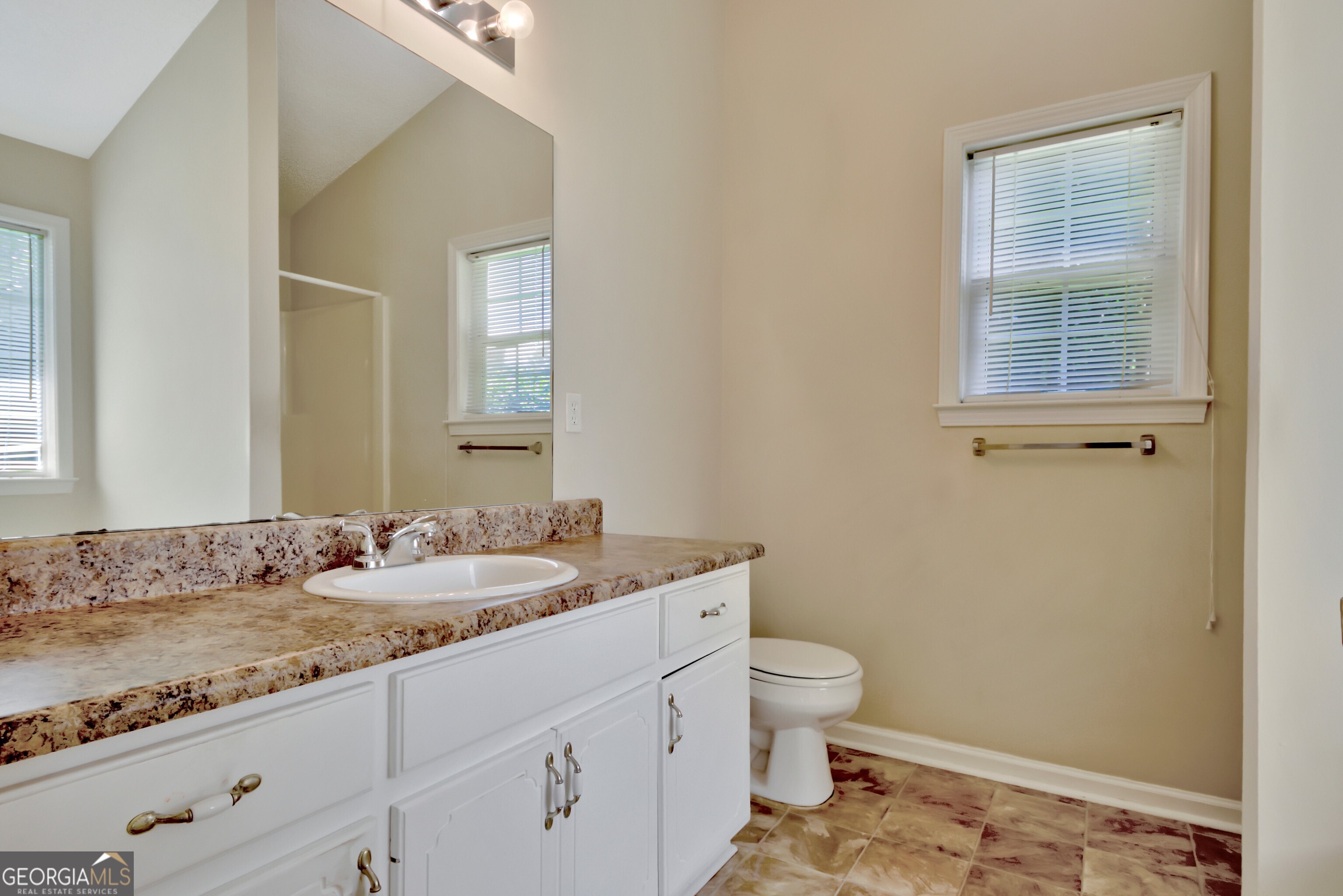 45 Paces Landing Drive Newnan, GA 30263 - Photo 19 of 31 a bathroom with a granite countertop sink a toilet and a mirror