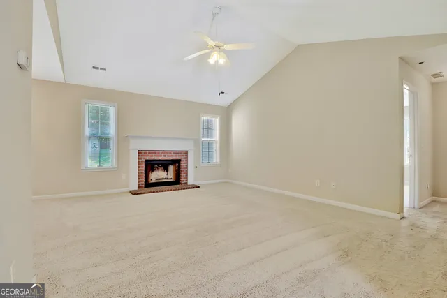 an empty room with a fireplace and a window