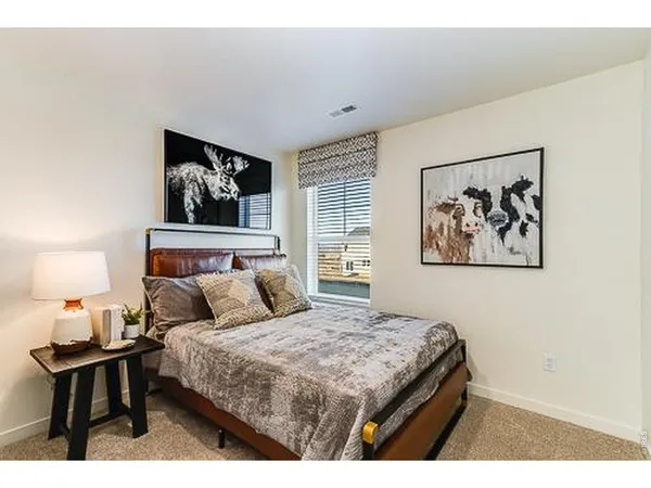 a bedroom with a bed and a painting on the wall