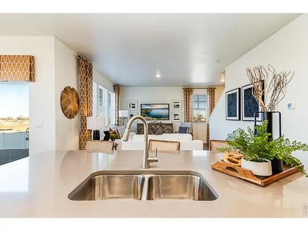 a kitchen with kitchen island a sink and a stove with living room