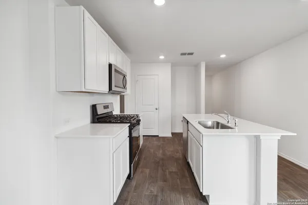 a kitchen with a stove sink and cabinets