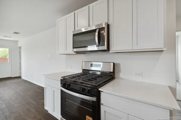 a kitchen with microwave cabinets and stove top oven
