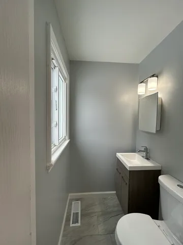 a bathroom with a toilet sink and mirror