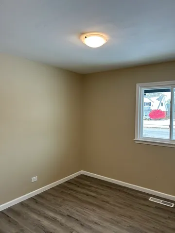 a view of a room with wooden floor and window