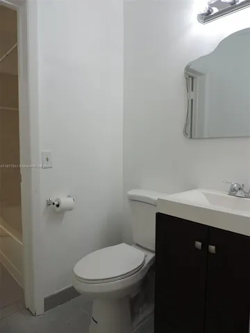 a bathroom with a toilet a sink and mirror