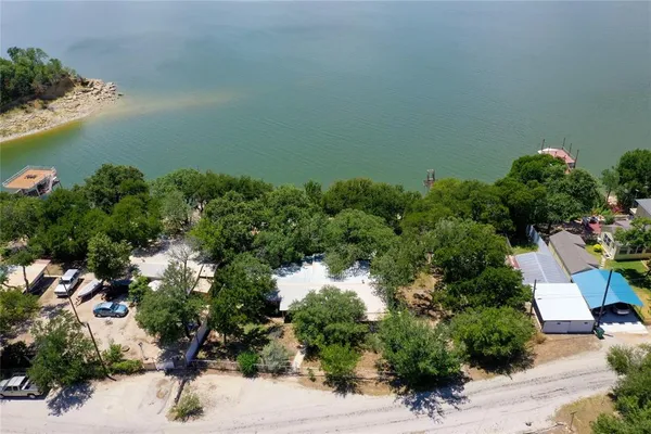 an aerial view of a house with a yard and lake view