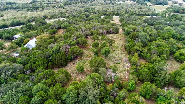 an aerial view of residential house with outdoor space and trees all around