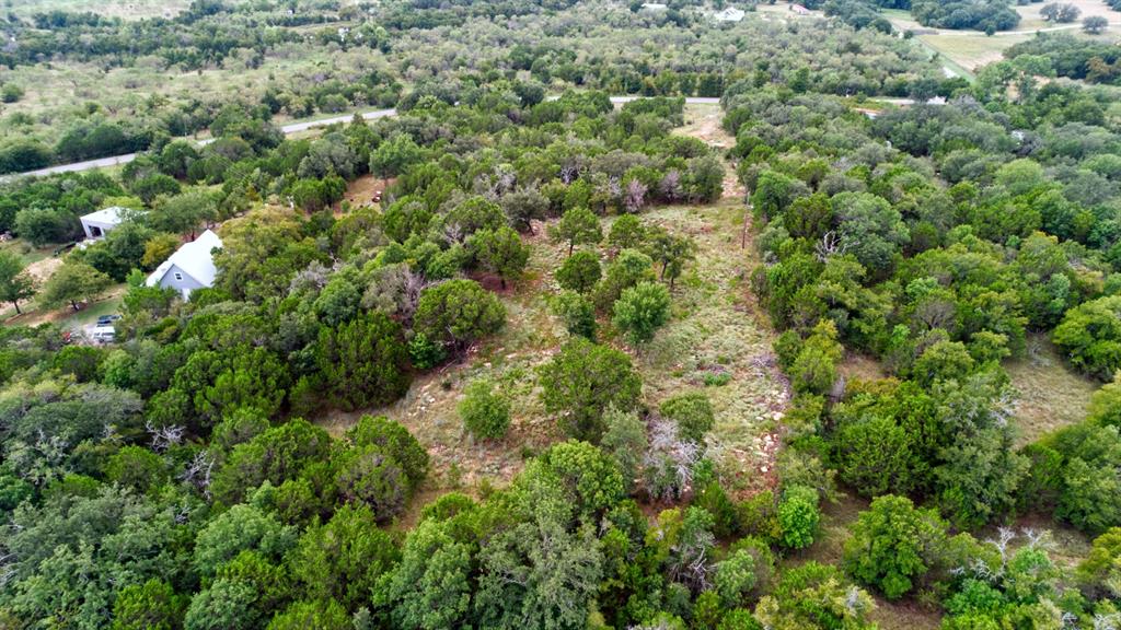an aerial view of residential house with outdoor space and trees all around