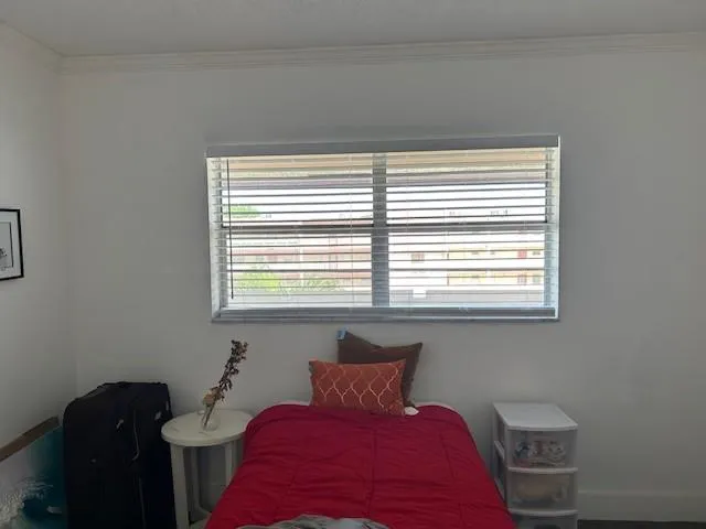 a bed sitting in a bedroom next to a window