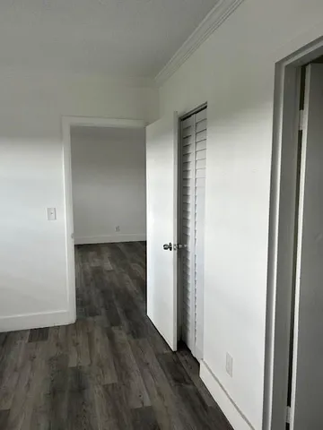 an empty room with wooden floor and entrance