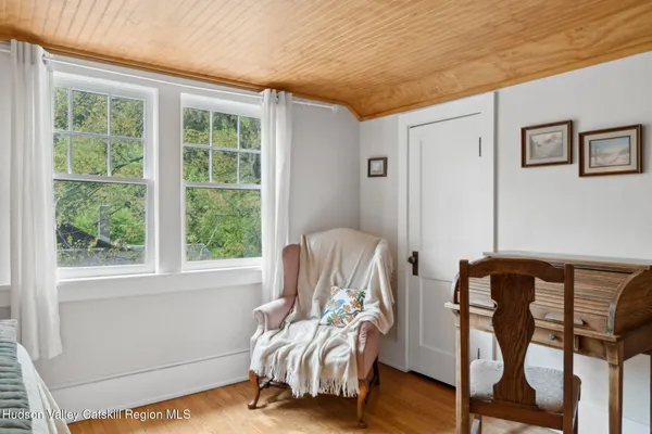 a living room with furniture wooden floor and a large window