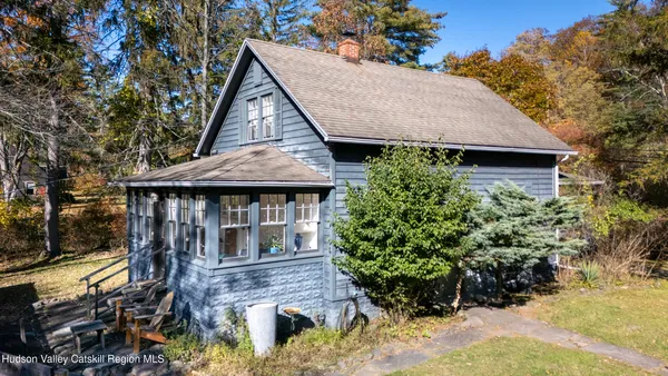 a front view of a house with a yard and potted plants
