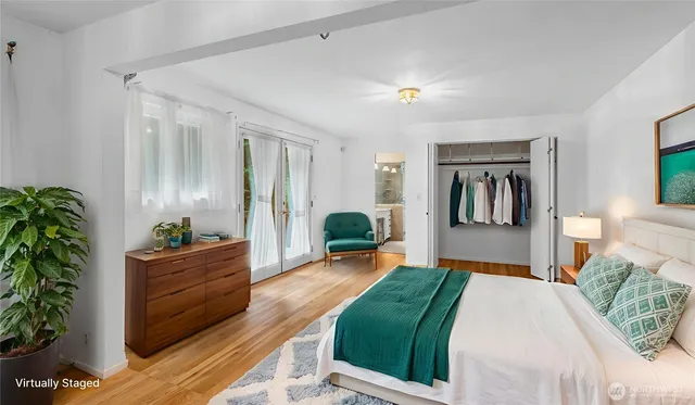 a bedroom with a large bed and a potted plant