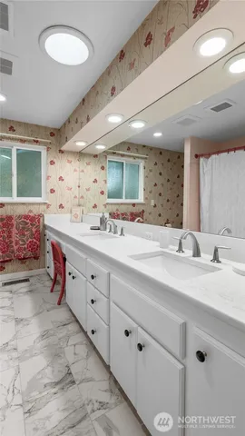 a spacious bathroom with double vanity sink a mirror and a bathtub