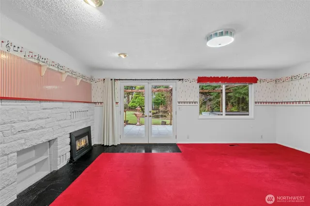 a view of an empty room with a fireplace and windows