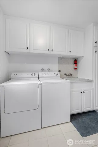 a utility room with cabinets washer and dryer
