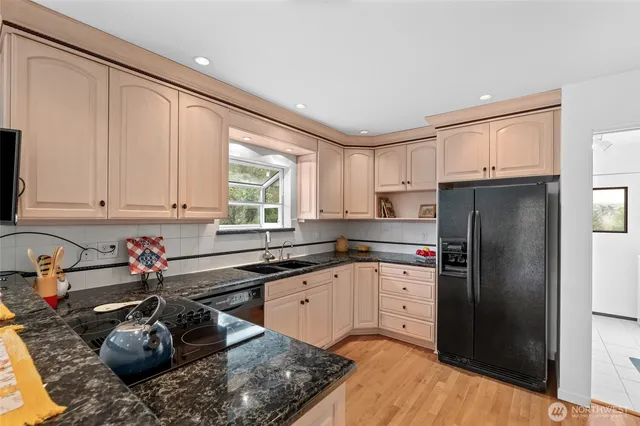 a kitchen with stainless steel appliances granite countertop a sink stove and refrigerator