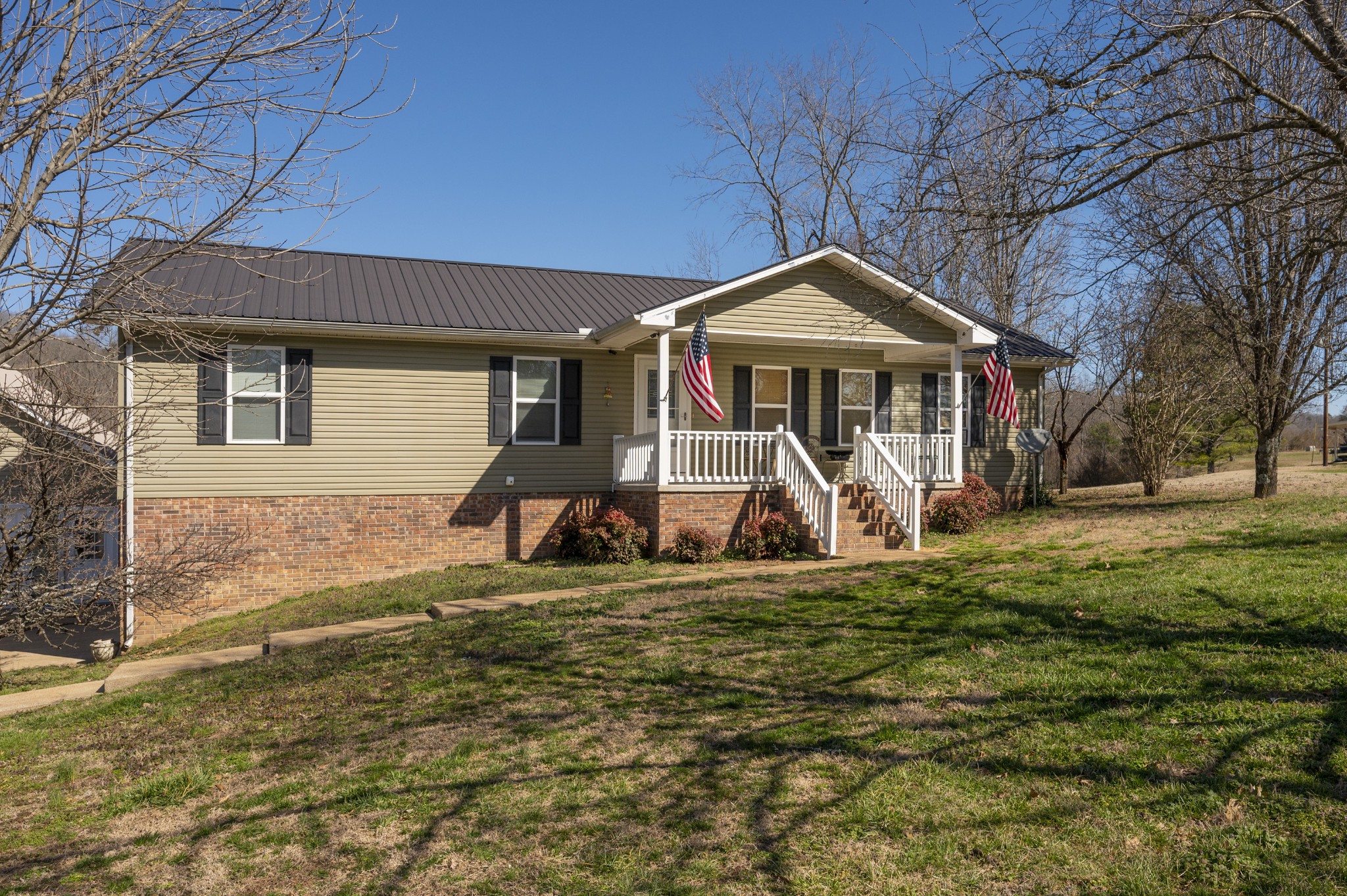 a view of a house with large trees and a yard