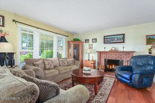 a living room with furniture fireplace and a large window
