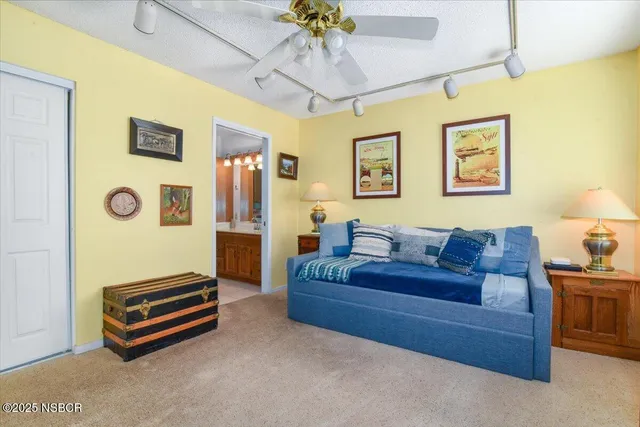 a spacious bedroom with a bed and a chandelier
