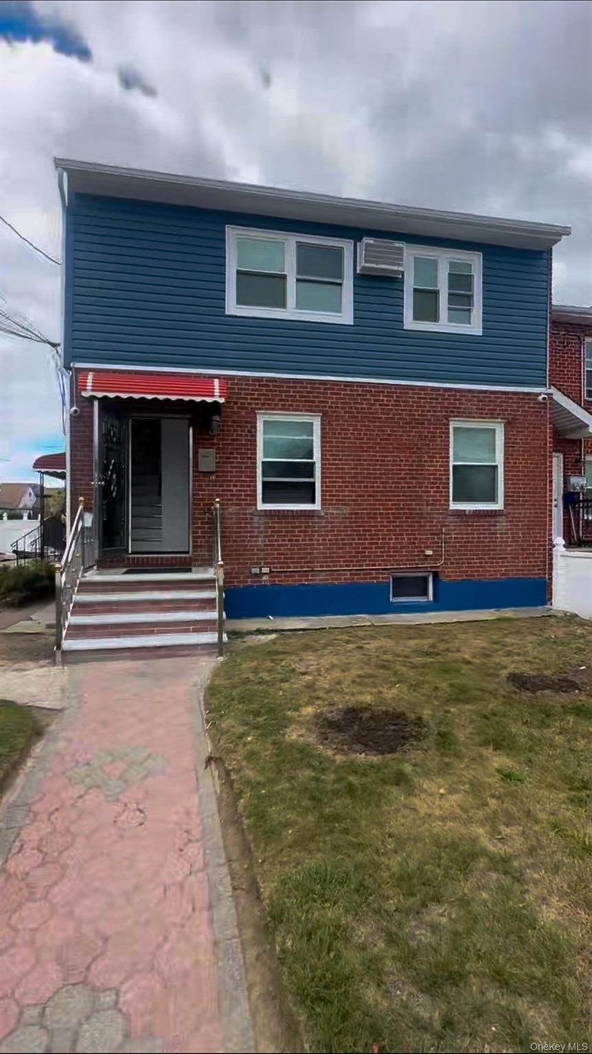 Traditional-style house featuring brick siding and a front lawn