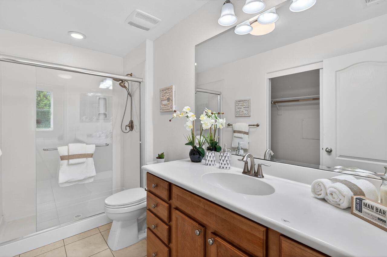 4712 Norris Canyon Road, Unit 104 San Ramon, CA 94583 - Photo 12 of 22 a bathroom with a granite countertop sink a toilet and a large mirror