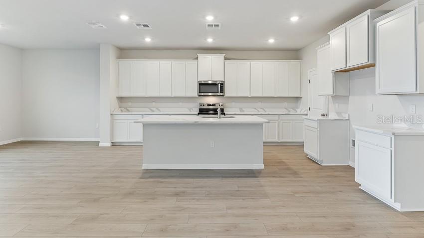 1925 Cobb Trail Parrish, FL 34219 - Photo 5 of 25 a kitchen with kitchen island sink stove and cabinets