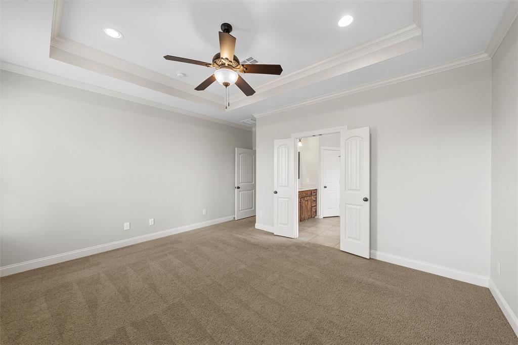 144 Ellis Farm Road Hewitt, TX 76643 - Photo 30 of 36 Spacious room featuring tray ceiling with recessed lighting and a ceiling fan, plush carpet flooring, white trim, and double doors opening to an adjoining space with a vanity