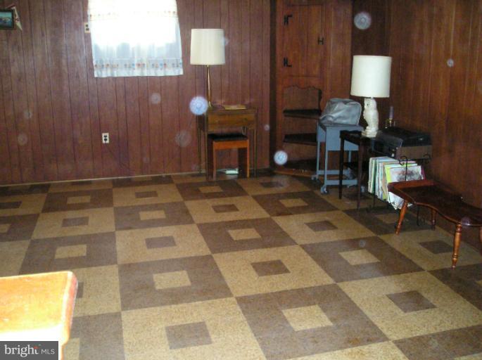 6813 Queens Ferry Road Baltimore, MD 21239 - Photo 15 of 19 a living room with a black white checkered floor with couches chair and a coffee table
