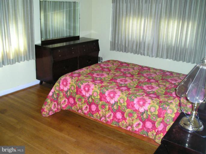 6813 Queens Ferry Road Baltimore, MD 21239 - Photo 5 of 19 a bedroom with a bed and a dresser