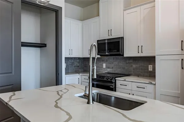 a kitchen with granite countertop a stove and a microwave