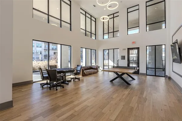 a living room with furniture pool table and wooden floor